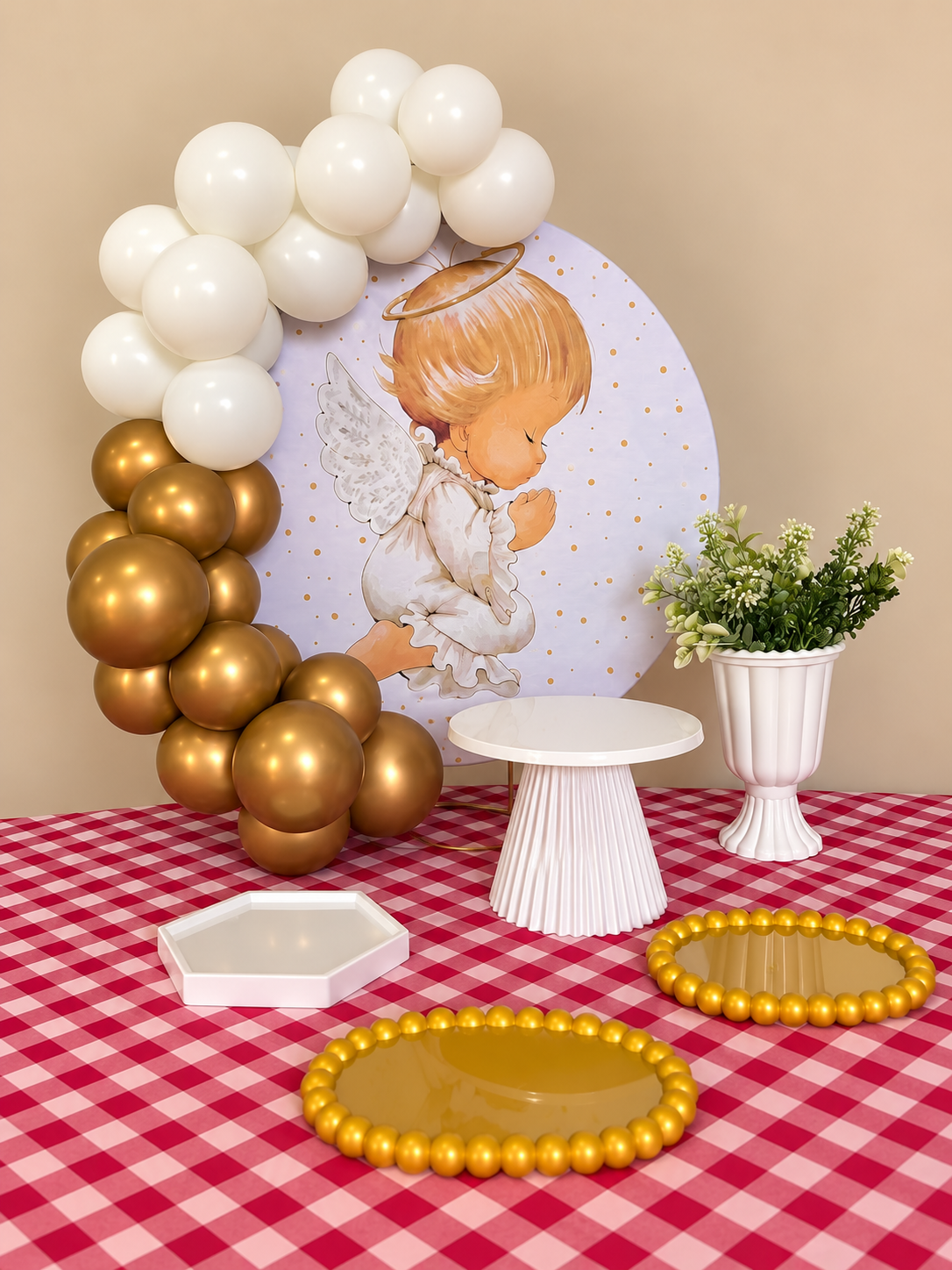Mesa de batizado com painel de anjo, balões brancos e dourados e suportes para doces